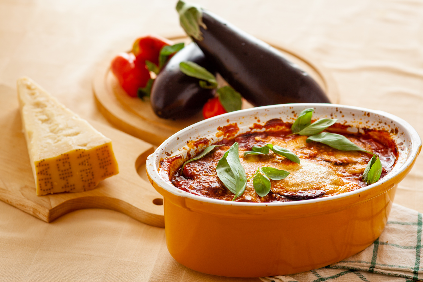 Home-baked melanzane alla parmigiana with basil, served with parmesan and fresh vegetables